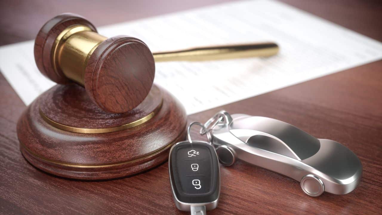 Richterhammer neben Autoschlüssel und Modellauto als Symbol für die rechtliche Pflicht zu Assistenzsystemen im Auto ab 2025 und eine transparente Schadenregulierung.