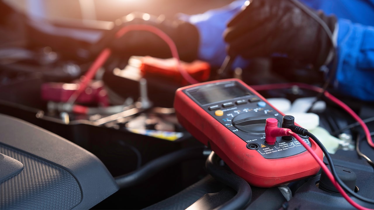 Messung der Autobatterie-Spannung mit Multimeter für zuverlässigen Start.